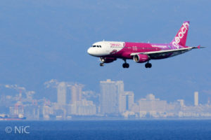 ビル群を着陸する飛行機